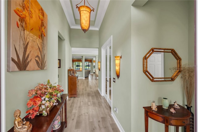 hall with french doors, baseboards, light wood-style flooring, and crown molding