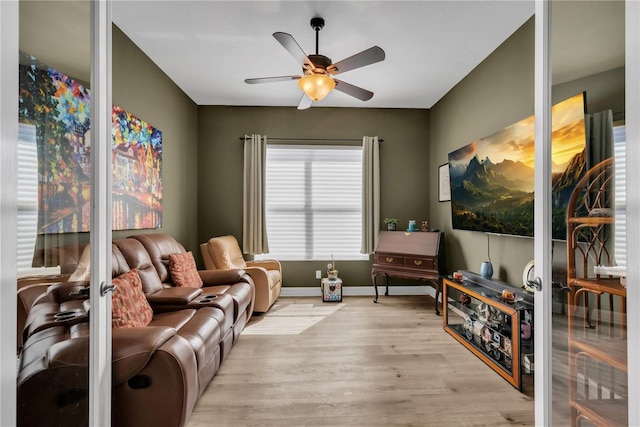 living area with ceiling fan, baseboards, and wood finished floors