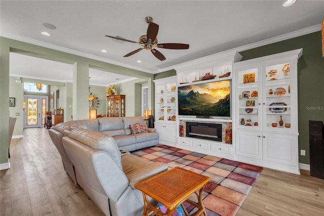 living room with ceiling fan, light wood-type flooring, ornamental molding, recessed lighting, and a fireplace