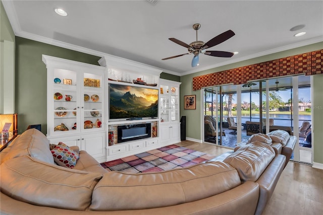 living area featuring light wood-style floors, a fireplace, and crown molding