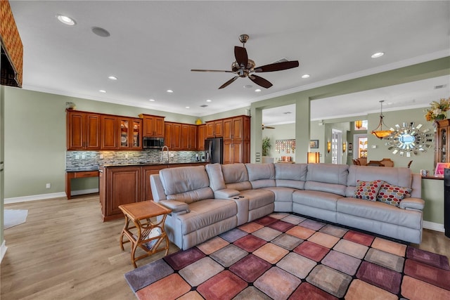 living room with recessed lighting, baseboards, light wood-style flooring, and ornamental molding