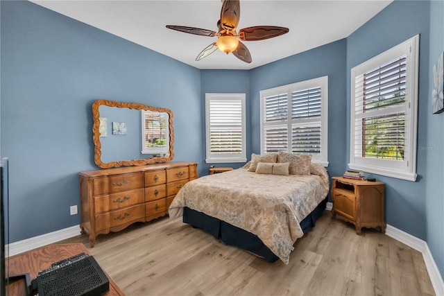 bedroom with baseboards, wood finished floors, and a ceiling fan