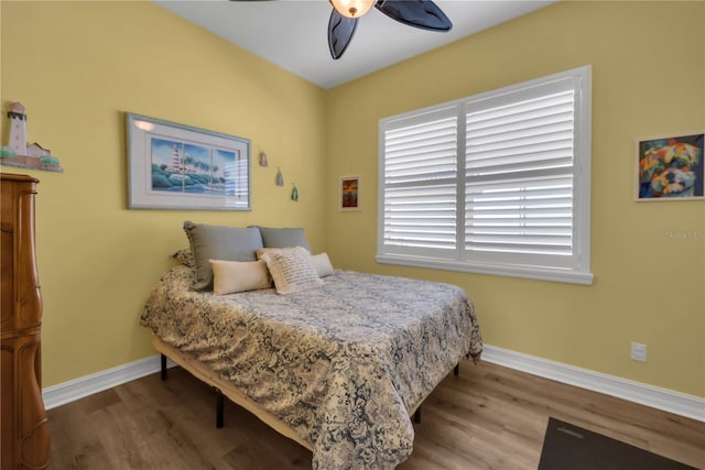 bedroom with ceiling fan, baseboards, and wood finished floors