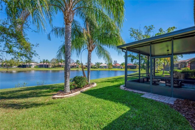 view of yard with a sunroom and a water view