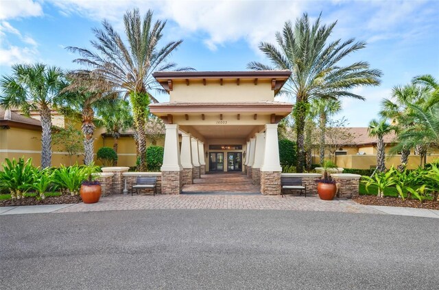 exterior space with stucco siding, stone siding, and french doors