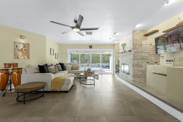 tiled living area featuring visible vents, ceiling fan, and a fireplace