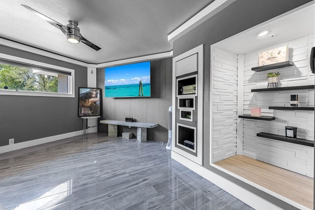 living area with baseboards and a ceiling fan