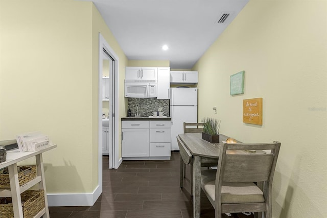 kitchen featuring white cabinetry, white appliances, decorative backsplash, baseboards, and wood tiled floor