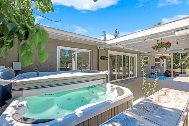 view of swimming pool featuring a patio area, a covered hot tub, and fence