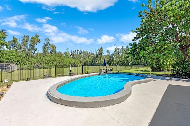 view of swimming pool featuring a patio area, a yard, a fenced in pool, and fence