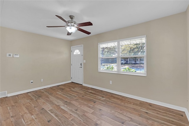 interior space featuring a ceiling fan, visible vents, wood finished floors, and baseboards