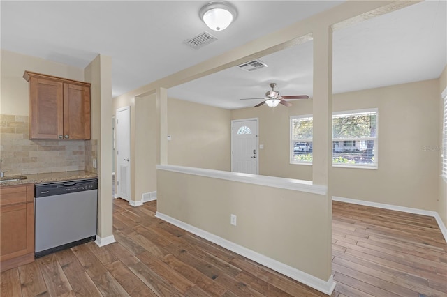 kitchen with wood finished floors, visible vents, baseboards, decorative backsplash, and stainless steel dishwasher