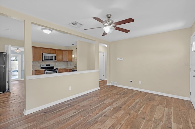 kitchen featuring light wood finished floors, visible vents, brown cabinets, and stainless steel appliances