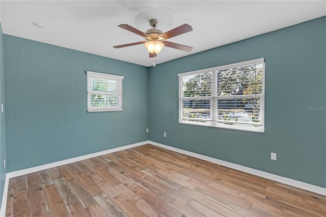 spare room featuring a ceiling fan, baseboards, and wood finished floors