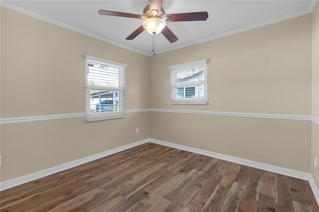 empty room with wood finished floors, crown molding, a healthy amount of sunlight, and baseboards