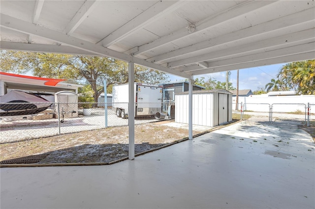 view of patio featuring a gate, a shed, an outdoor structure, and fence