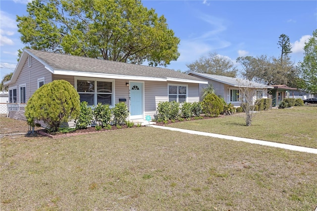 single story home with a shingled roof and a front lawn