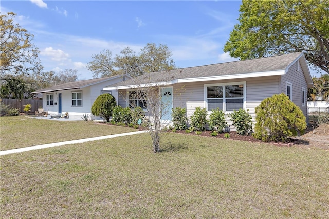 ranch-style home with a front lawn and fence