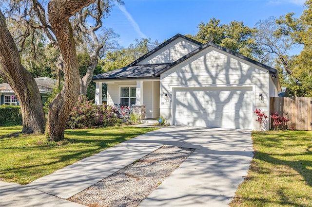 view of front of property with concrete driveway, fence, a garage, and a front yard