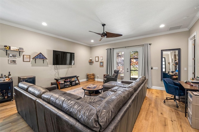 living room featuring baseboards, ceiling fan, ornamental molding, french doors, and light wood-type flooring