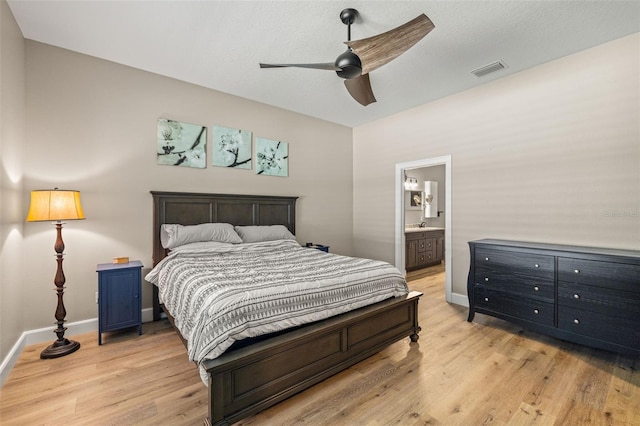 bedroom with visible vents, baseboards, ensuite bath, and light wood-style flooring