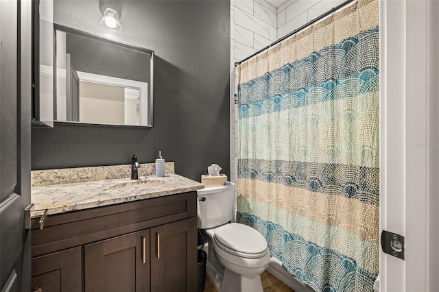 bathroom featuring a shower with curtain, toilet, vanity, and a textured wall