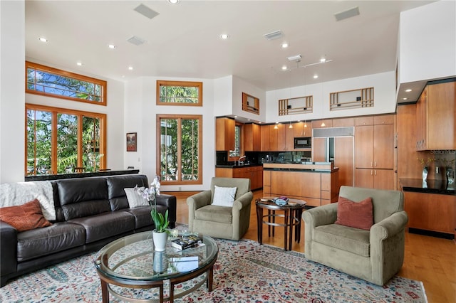 living area featuring recessed lighting, visible vents, and light wood-style flooring