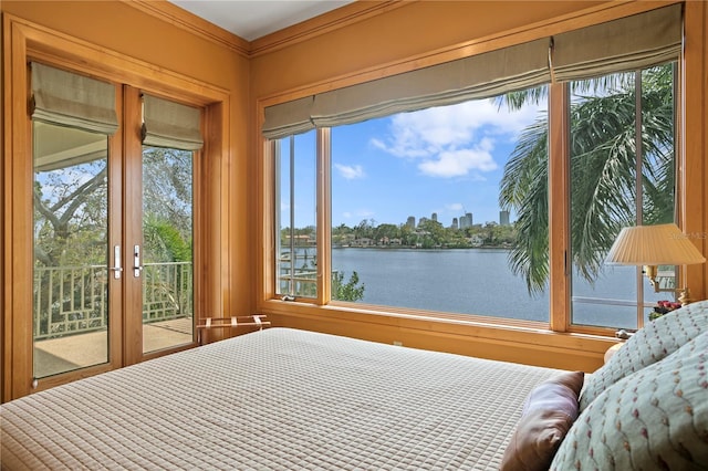 unfurnished bedroom with crown molding, access to outside, and a water view