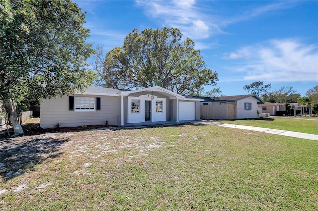 single story home featuring a garage, concrete driveway, and a front yard