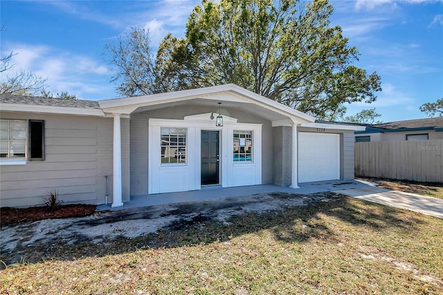 view of front facade featuring brick siding, concrete driveway, an attached garage, and fence