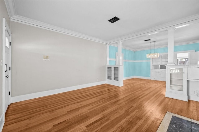 unfurnished living room featuring baseboards, visible vents, decorative columns, crown molding, and light wood-type flooring