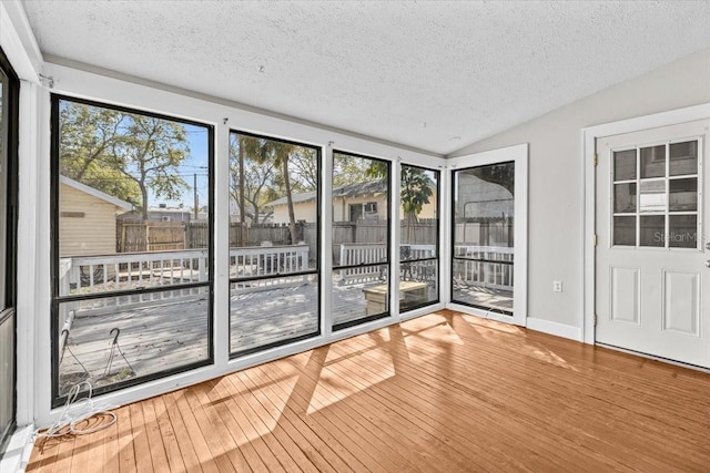 unfurnished sunroom featuring vaulted ceiling