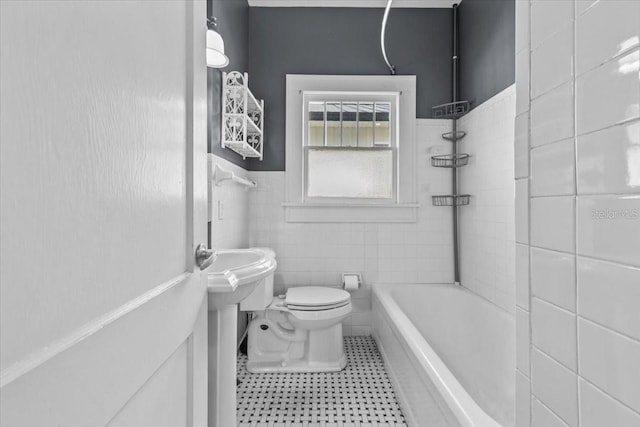 full bathroom featuring toilet, shower / bath combination, wainscoting, tile patterned floors, and tile walls