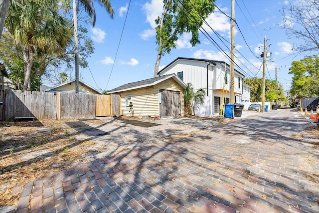 exterior space featuring decorative driveway and fence