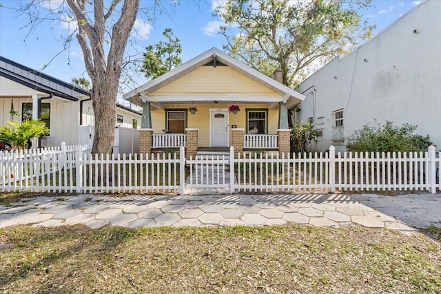 view of front of home with a fenced front yard and a porch