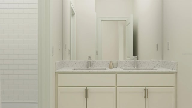 bathroom with double vanity, a shower, and a sink