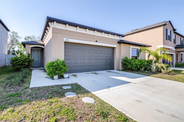 view of front of home with stucco siding, concrete driveway, and an attached garage