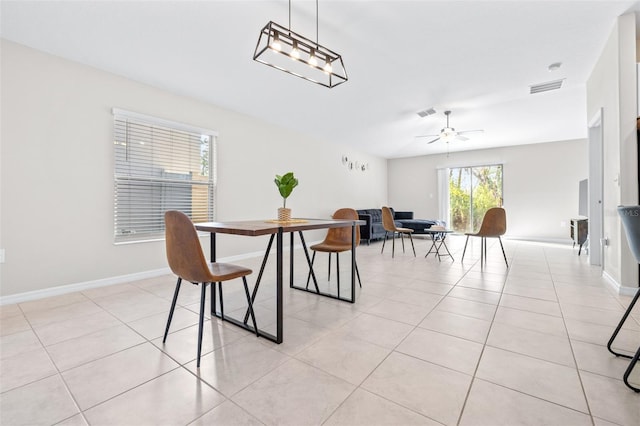 dining room with light tile patterned floors, a ceiling fan, visible vents, and baseboards