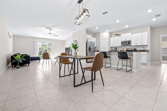 dining area featuring light tile patterned floors, baseboards, and visible vents