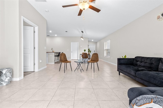 living area featuring visible vents, ceiling fan, baseboards, lofted ceiling, and light tile patterned floors