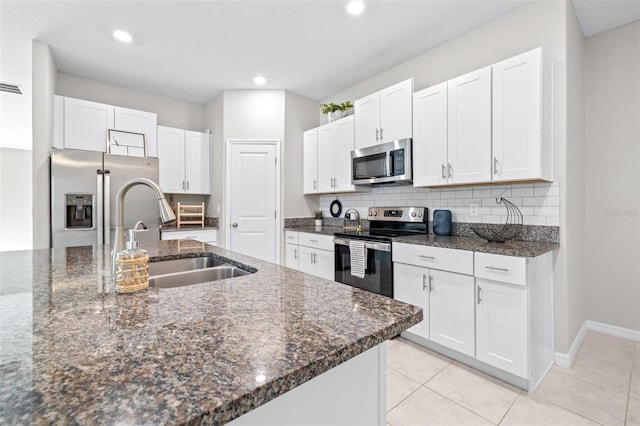 kitchen with a sink, white cabinets, tasteful backsplash, and stainless steel appliances