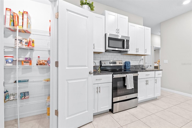 kitchen with tasteful backsplash, appliances with stainless steel finishes, and white cabinetry