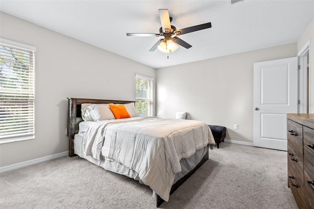 carpeted bedroom with a ceiling fan and baseboards