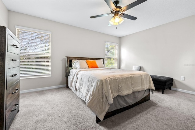 bedroom featuring baseboards, light colored carpet, and a ceiling fan