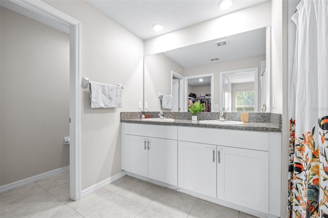 full bathroom featuring a sink, visible vents, baseboards, and double vanity