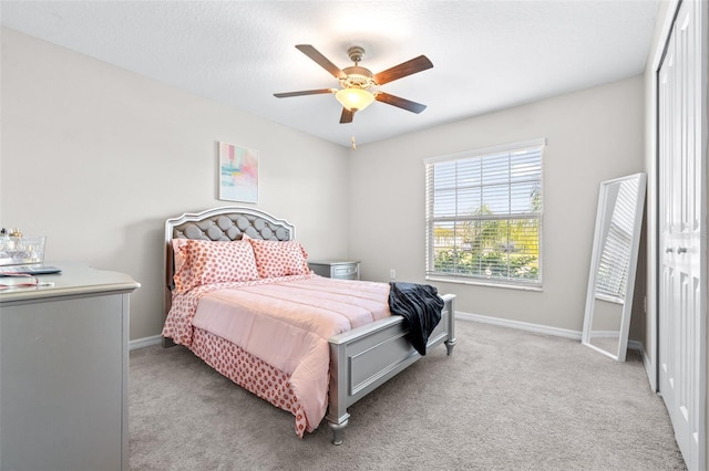 bedroom featuring light colored carpet, a ceiling fan, and baseboards