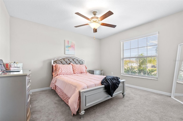 bedroom featuring baseboards, light colored carpet, and a ceiling fan