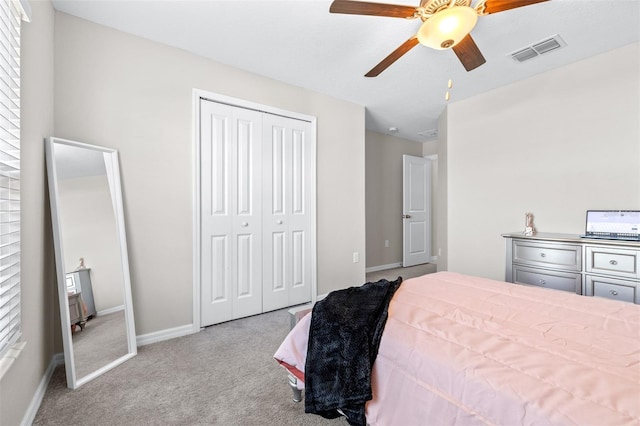 carpeted bedroom featuring visible vents, baseboards, a closet, and a ceiling fan