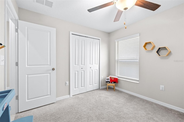 unfurnished bedroom featuring a ceiling fan, baseboards, visible vents, a closet, and carpet flooring