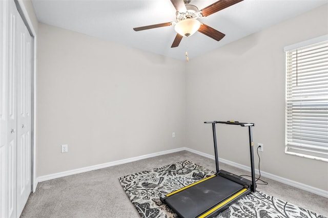 exercise area featuring baseboards, carpet, and ceiling fan